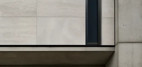Detailansicht einer präzise gegliederten Fassade aus hellem Stein und dunklem Metall